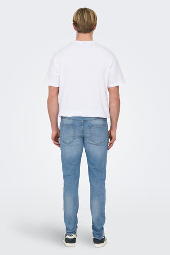 Jean slim fit en denim bleu clair de ONLY & SONS, vu de derrière, avec un T-shirt blanc et des baskets noires.