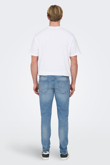 Jean slim fit en denim bleu clair de ONLY & SONS, vu de derrière, avec un T-shirt blanc et des baskets noires.