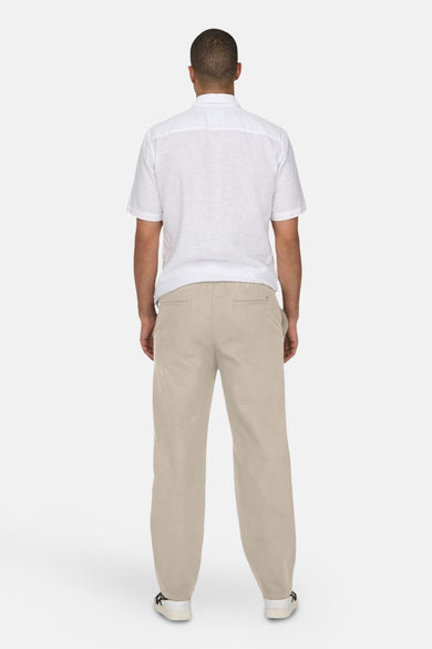 Pantalon écru de ONLY & SONS, vu de derrière, avec une blouse blanche et des chaussures.