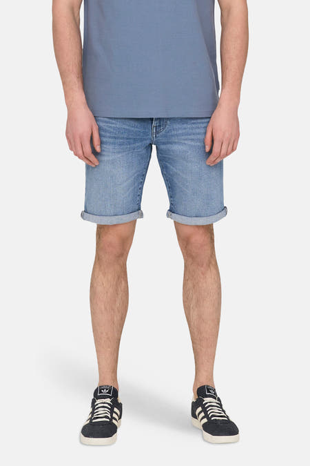 Short en jean en denim bleu moyen de ONLY & SONS, avec ourlets retroussés et associé à un polo bleu et des baskets.