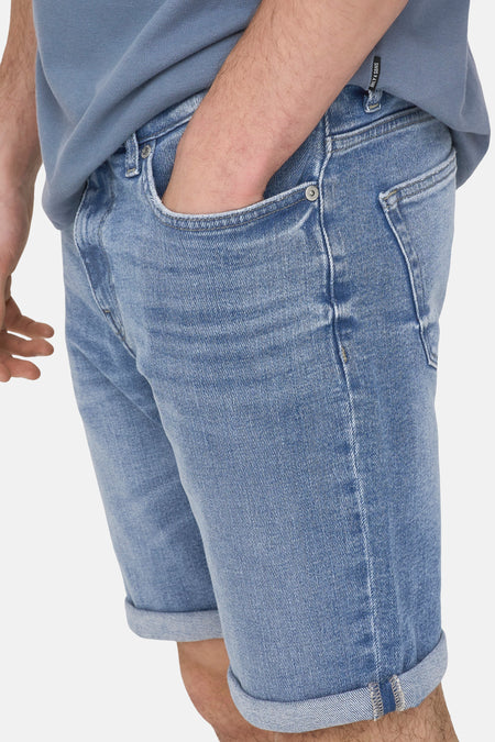Short en jean en denim bleu moyen de ONLY & SONS, avec ourlets retroussés et une main dans la poche.