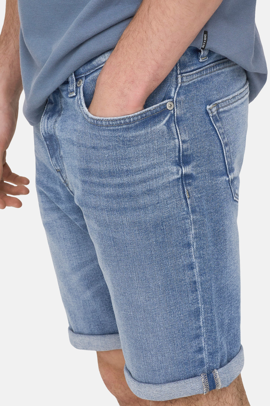 Short en jean en denim bleu moyen de ONLY & SONS, avec ourlets retroussés et une main dans la poche.