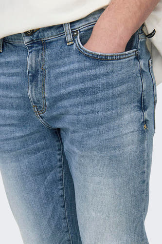 Jean slim fit bleu clair d'ONLY & SONS, avec une main dans la poche.