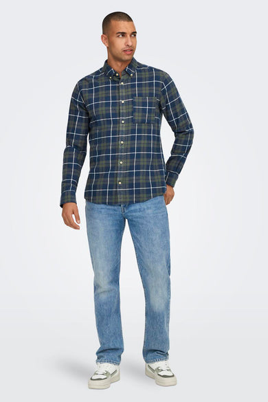 Chemise verte à manches longues de ONLY & SONS®, conçue avec des manches longues, portée avec des jeans et des baskets.