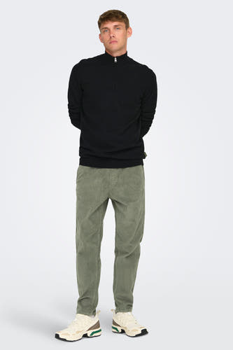 Pantalon gris de ONLY & SONS®, avec une texture en côtes, associé à un pull noir et des chaussures blanches.