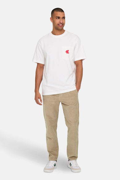 Pantalon beige d'ONLY & SONS, avec une texture corduroy, associé à un T-shirt blanc et des baskets.
