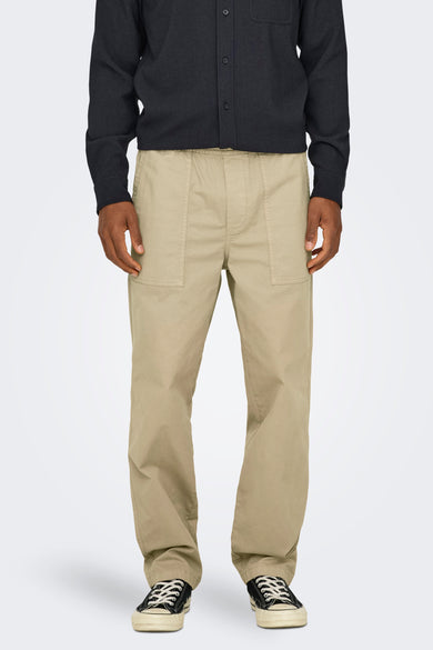Pantalon beige ONLY & SONS® avec poches arrière, associé à une chemise noire et des chaussures noires.
