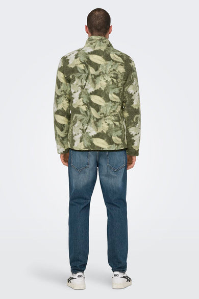 Fausse polaire multicolore d'ONLY & SONS® avec un motif de feuilles, portée avec des jeans bleus foncés et des baskets blanches.