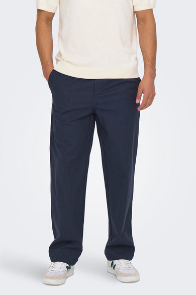 Pantalon bleu d'ONLY & SONS, avec des rayures de craie et des poches arrière, porté avec un polo crème et des baskets blanches.