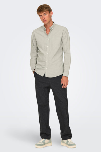 Pantalon noir de ONLY & SONS, associé à une chemise gris clair et des baskets crème.