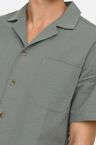 T-shirt kaki à manches courtes de ONLY & SONS®, avec une texture tissée subtile et une poche poitrine.