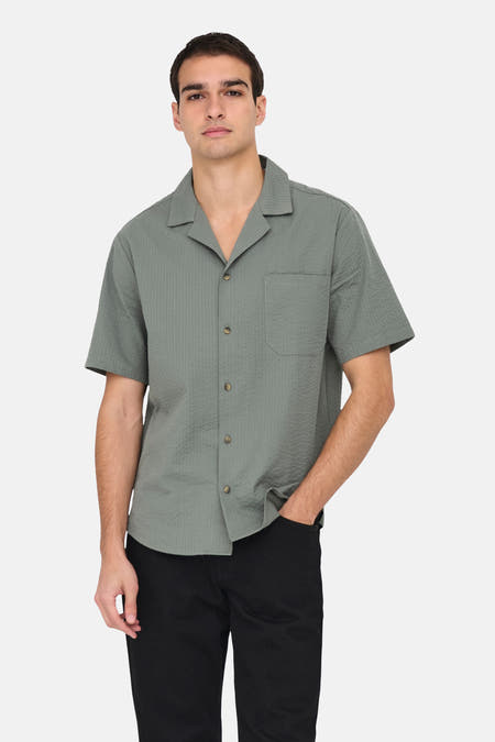 T-shirt kaki à manches courtes de ONLY & SONS®, texture lisse, avec un pantalon noir.