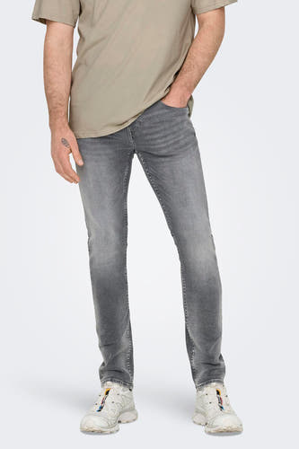 Jean slim fit en denim gris moyen de ONLY & SONS, avec un léger lavage et des baskets blanches.