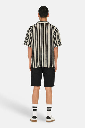 Chemise rayée à manches courtes ONLY & SONS®, dos, associée à un short noir et des chaussettes blanches à rayures.
