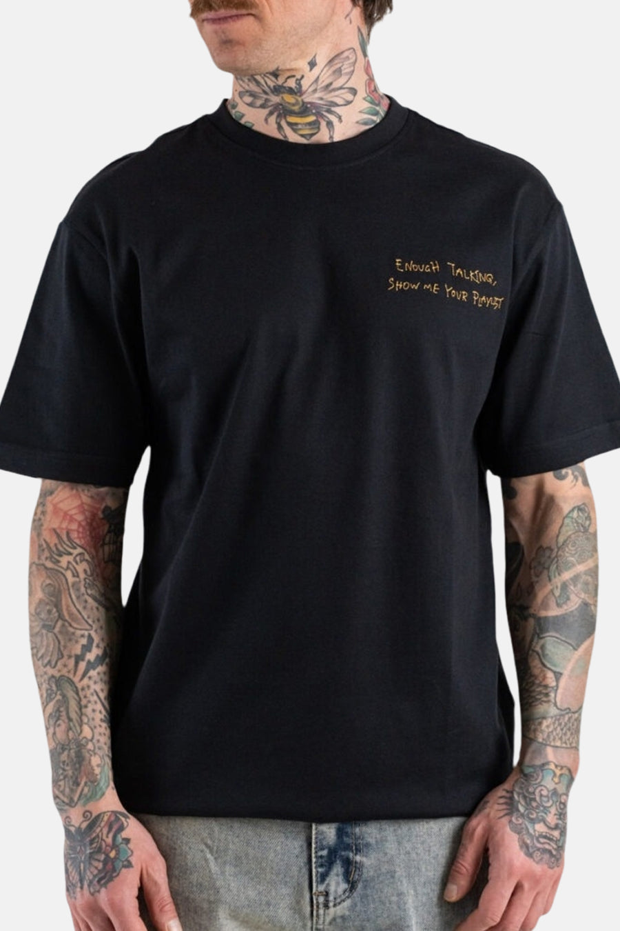 T-shirt noir à manches courtes ONLY & SONS®, avec imprimé jaune et tatouages visibles.