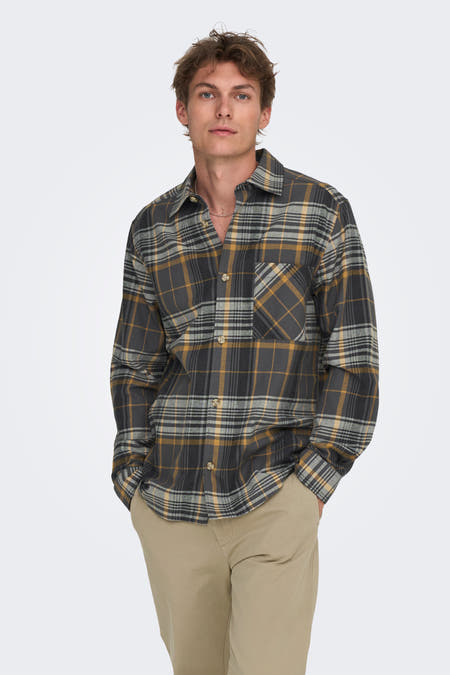 Chemise grise à manches longues de ONLY & SONS®, avec un motif carreaux, associée à un pantalon kaki et des chaussures en cuir de mouton.