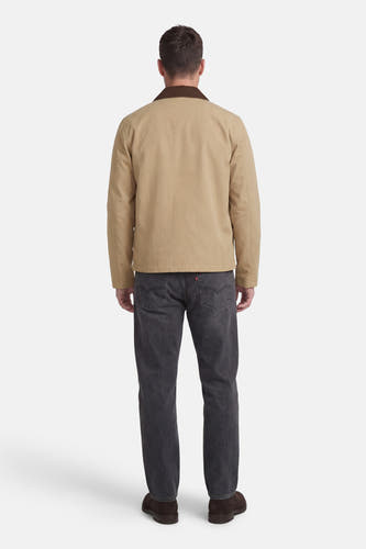 Beige korte jas van ONLY & SONS®, met bruine kraag, gecombineerd met grijze jeans en bruine schoenen, van achteren gezien.