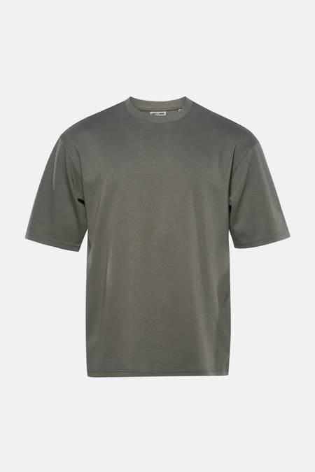 T-shirt vert à manches courtes ONLY & SONS®, porté avec un jean bleu et des baskets blanches.