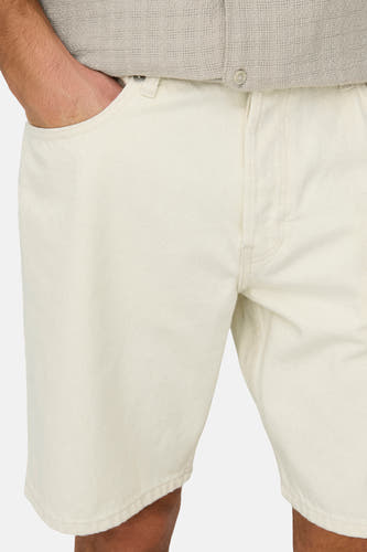 Short en jean écru de ONLY & SONS®, avec poches latérales et coutures subtiles, combiné avec une chemise beige légère.