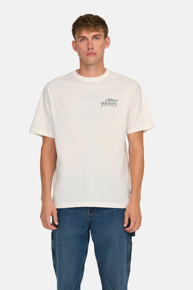 T-shirt écru à manches courtes de ONLY & SONS, avec une petite impression de texte vert foncé sur la poitrine, associé à des jeans bleus.