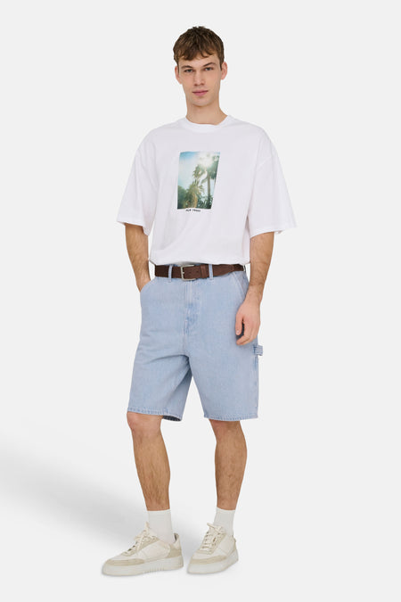 Lichtblauwe denim short van ONLY & SONS® in worker-stijl, gecombineerd met een wit T-shirt en crèmekleurige sneakers.