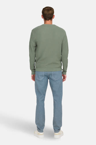 T-shirt vert avec col rond de ONLY & SONS®, porté avec des jeans bleus et des baskets crème.