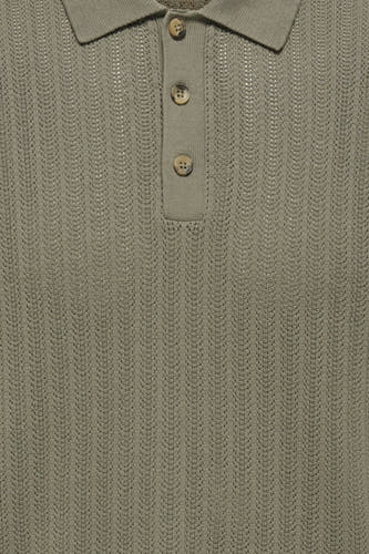 Polo kaki à manches courtes ONLY & SONS® avec texture côtelée et boutons aspect bois, portée avec un jean foncé.