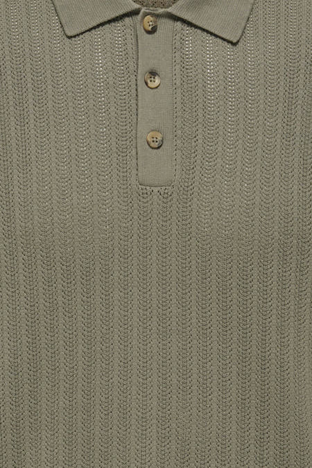 Polo kaki à manches courtes ONLY & SONS® avec texture côtelée et boutons aspect bois, portée avec un jean foncé.