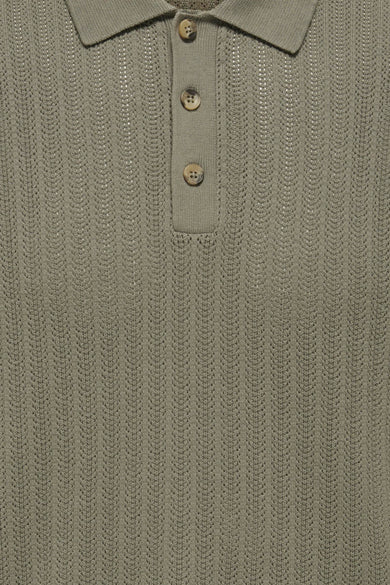 Polo kaki à manches courtes ONLY & SONS® avec texture côtelée et boutons aspect bois, portée avec un jean foncé.