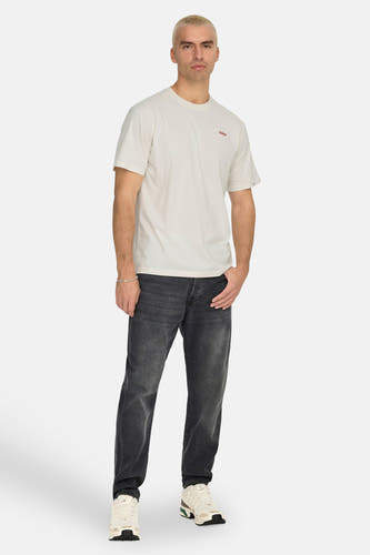 Ecru T-shirt met korte mouwen van ONLY & SONS, met klein logo op de borst, gecombineerd met een jeans en sneakers.
