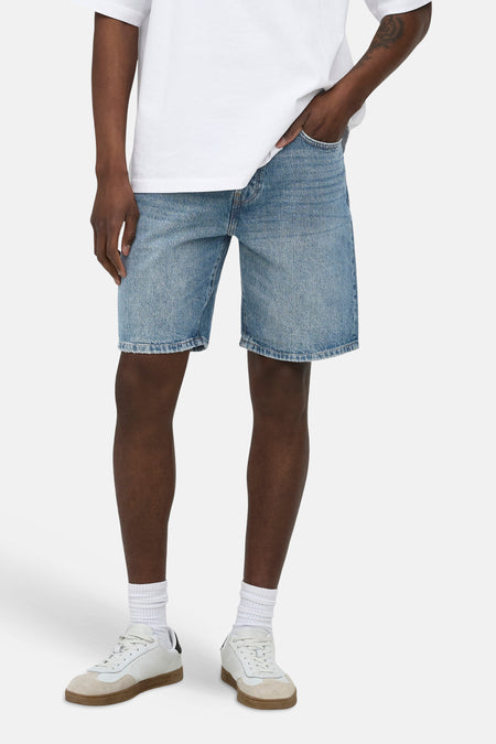 Short en jean bleu moyen ONLY & SONS®, longueur genou, porté par un homme avec un t-shirt blanc et des baskets blanches.