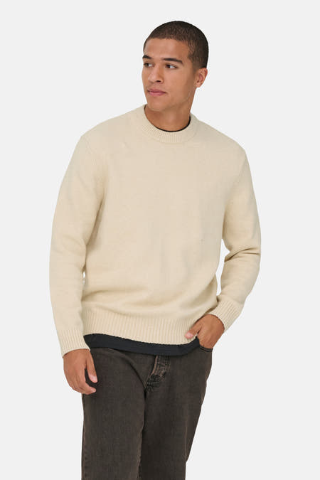 T-shirt écru avec col rond de ONLY & SONS®, à longues manches, associé à des jeans foncés et des chaussures noires.