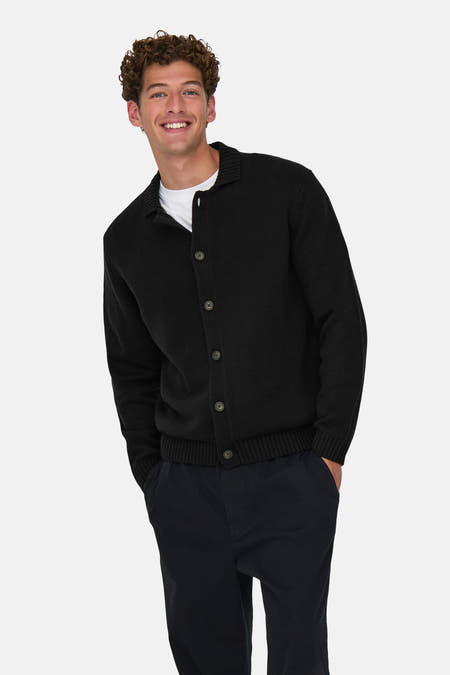 Veste noire ONLY & SONS® avec fermeture à boutons, portée sur un T-shirt blanc et des pantalons foncés.