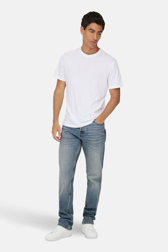 Jean droit en denim bleu de ONLY & SONS, porté avec un T-shirt blanc et des baskets blanches.