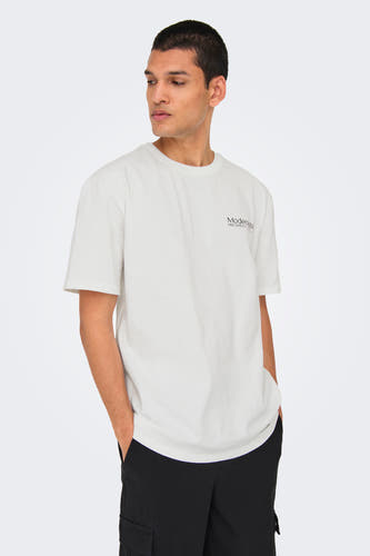 T-shirt blanc à manches courtes d'ONLY & SONS, avec une petite impression sur la poitrine, associé à un pantalon noir.