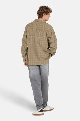 Chemise beige à longues manches de ONLY & SONS, avec un motif de fenêtre subtil, associée à des jeans gris et des baskets blanches.