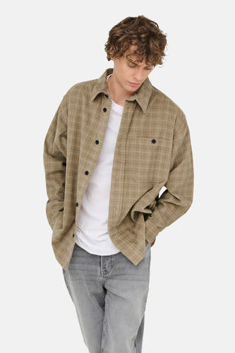 Chemise beige à longues manches de ONLY & SONS®, à carreaux, portée sur un T-shirt blanc et des jeans gris.