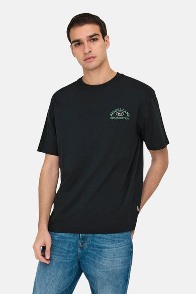 T-shirt noir à manches courtes de ONLY & SONS®, avec une petite impression de texte vert sur la poitrine, porté avec des jeans.