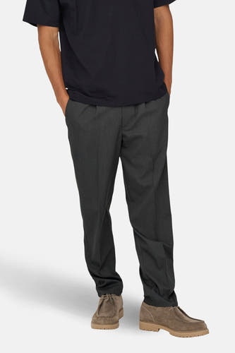 Pantalon gris d'ONLY & SONS®, avec poches et coupe décontractée, associé à des chaussures brunes et un T-shirt noir.