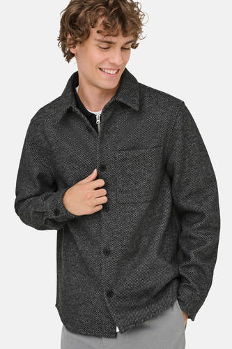Chemise grise à manches longues de ONLY & SONS, avec poche poitrine et fermeture à boutons, portée sur une chemise à fermeture éclair.