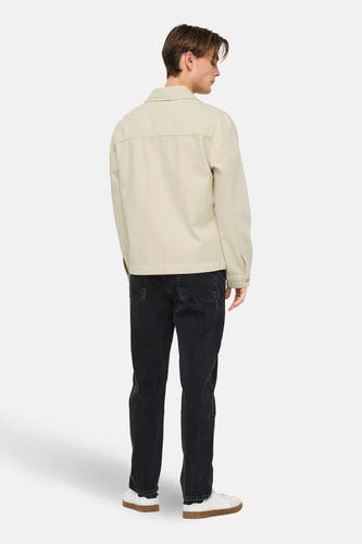 Veste en jean écru de ONLY & SONS®, à manches longues, coupe droite et portée avec un jean noir et des baskets blanches.