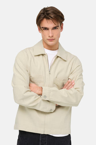 Veste en jean écru de ONLY & SONS®, à manches longues et fermeture à glissière, portée sur un t-shirt blanc.