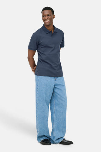 Donkerblauwe korte mouwen polo van ONLY & SONS® met ribstructuur, gedragen met lichtblauwe jeans en zwarte schoenen, front view.