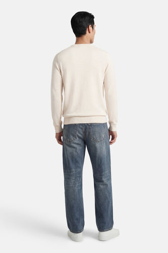 Ecrukleurige trui met ronde hals van ONLY & SONS, met lange mouwen, gedragen met een spijkerbroek en witte schoenen, achterkant.