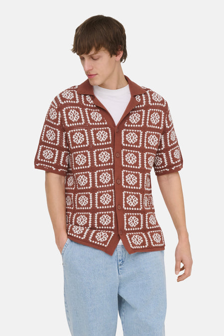 Pull en maille marron de ONLY & SONS avec motifs carrés blancs, col et manches courtes, porté sur un t-shirt blanc et un jean clair.