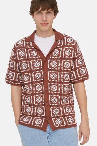 Pull en maille marron ONLY & SONS® avec motif carré blanc ressemblant à des flocons de neige, porté sur un t-shirt blanc et un jean clair.