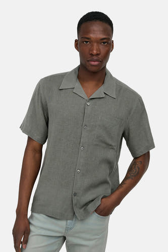 Chemise kaki à manches courtes ONLY & SONS® en tissu texturé, avec col à revers et poche poitrine, portée par un homme.
