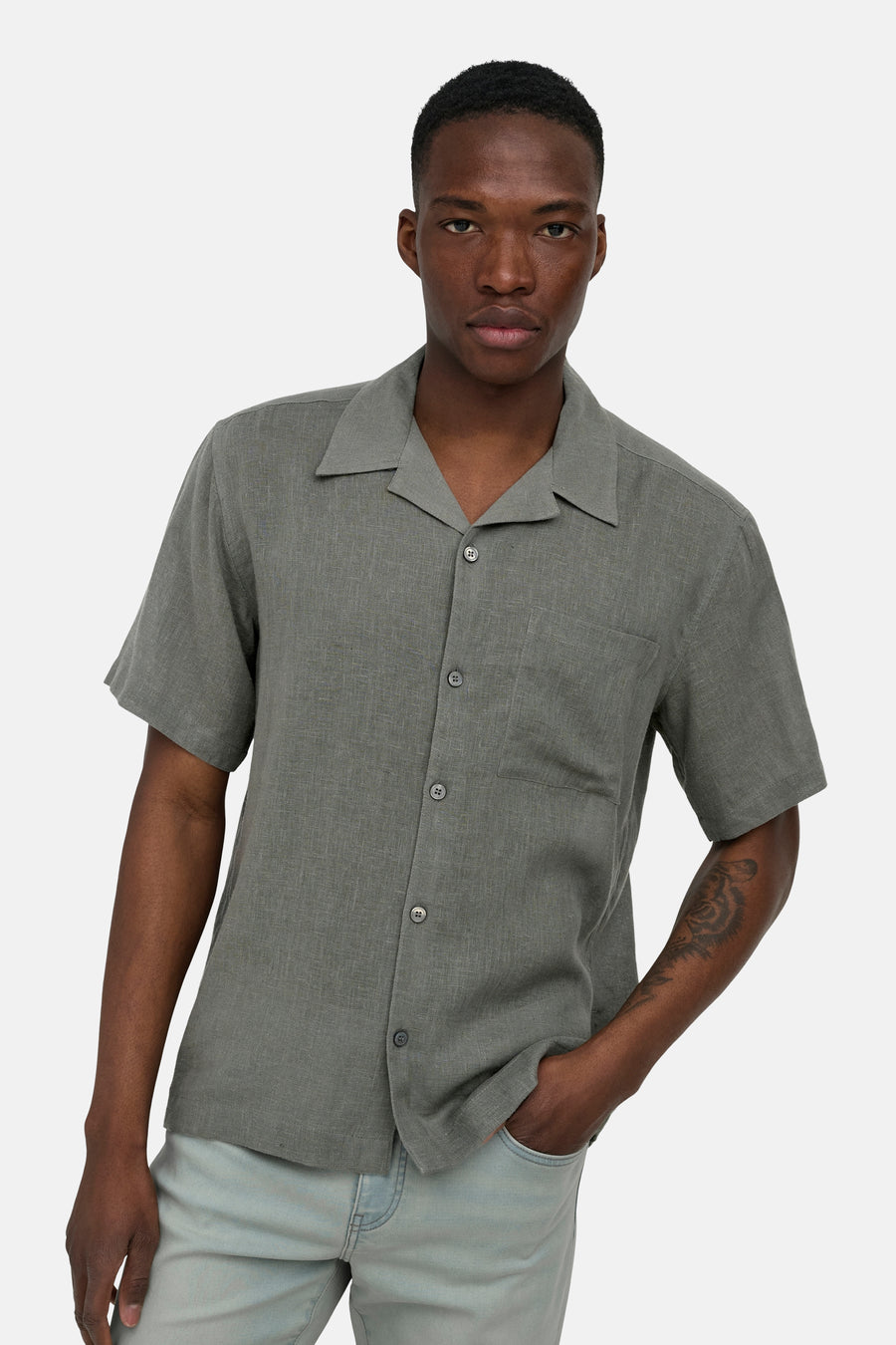 Chemise kaki à manches courtes ONLY & SONS® en tissu texturé, avec col à revers et poche poitrine, portée par un homme.