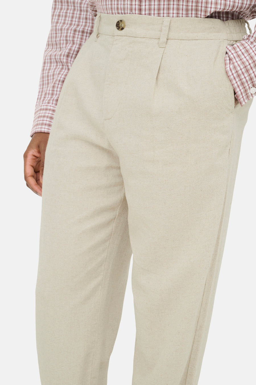 Pantalon beige de ONLY & SONS avec fermeture à boutons, devant plissé et taille élastique, porté avec une chemise à carreaux.