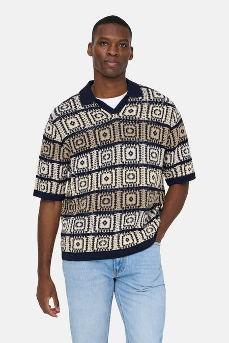Pull à col en V multicolore de ONLY & SONS®, avec motifs géométriques, combiné avec un jean bleu clair et des chaussures noires.